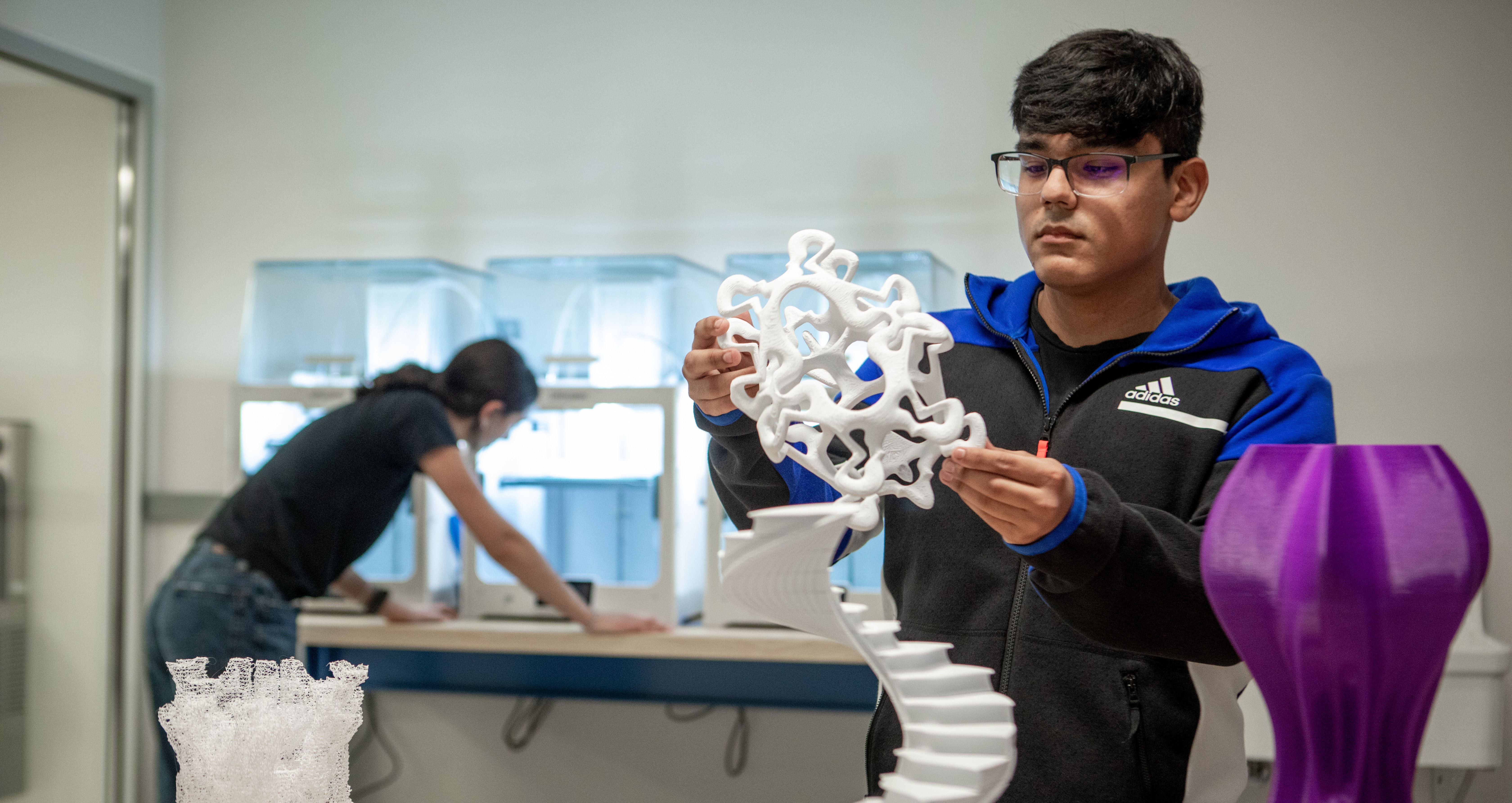 student examining sculpture in 3D printing lab