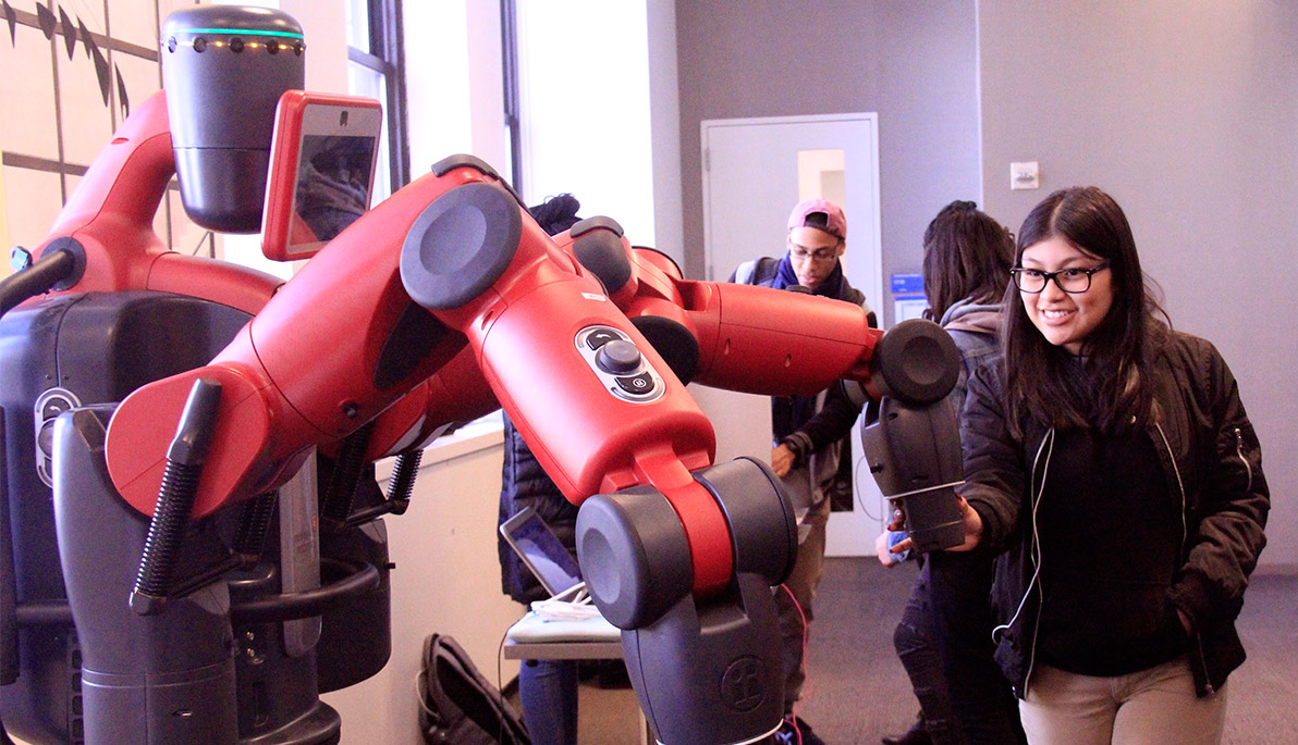 A student examining a robot.