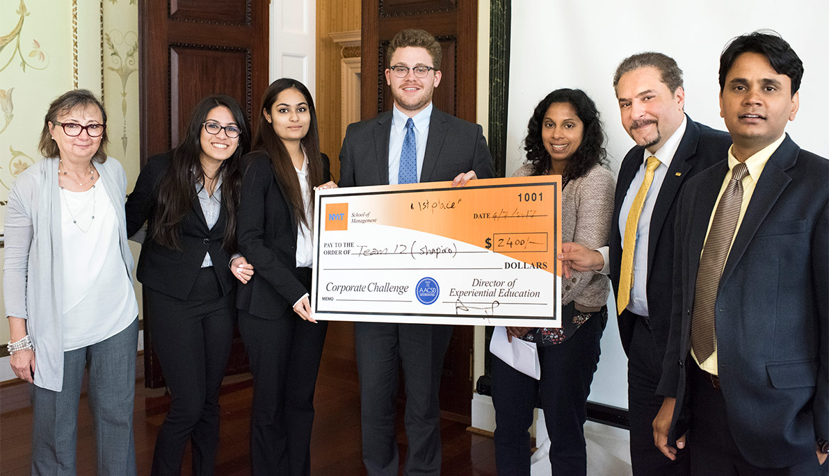Students who participated in NYIT School of Management’s Corporate Challenge competition stand with their check for first place.