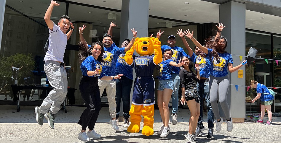 Students cheering with mascot outside NYC campus