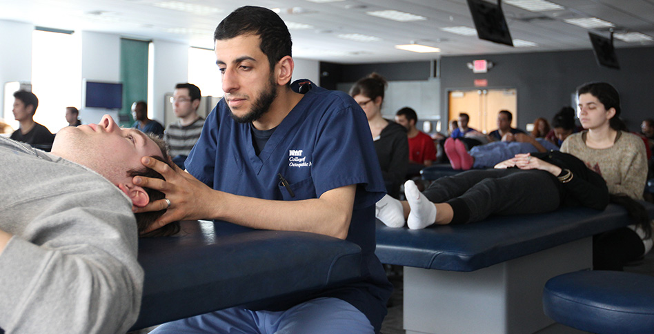 NYITCOM student practicing his skills on a patient