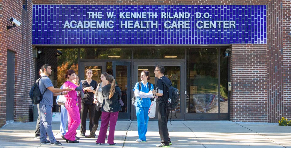 NYITCOM students standing in front of the Riland academic health care center