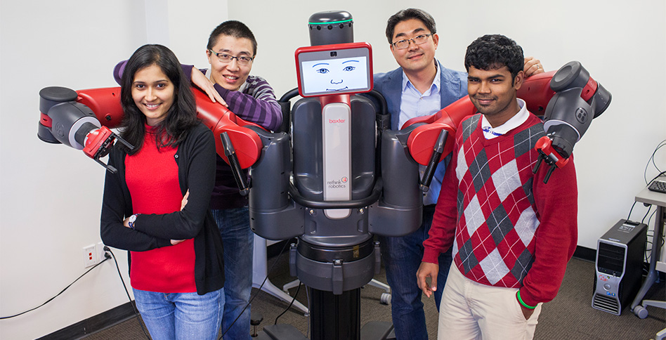 Students and faculty pose together with robot