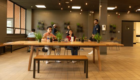 Students sitting around table in remodeled cafe space