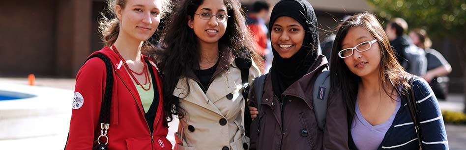 Four female students posing together on the Long Island campus