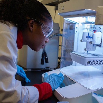 Woman scientist using lab machinery in new engineering and biology lab