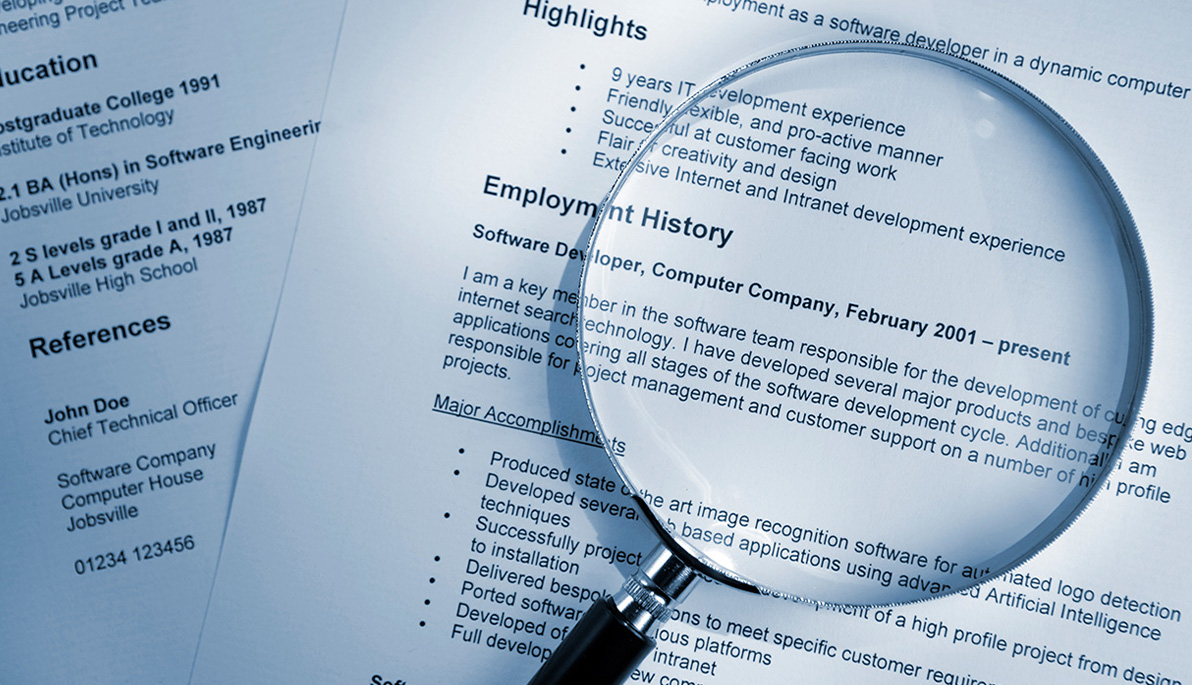 Magnifying glass on top of a resume
