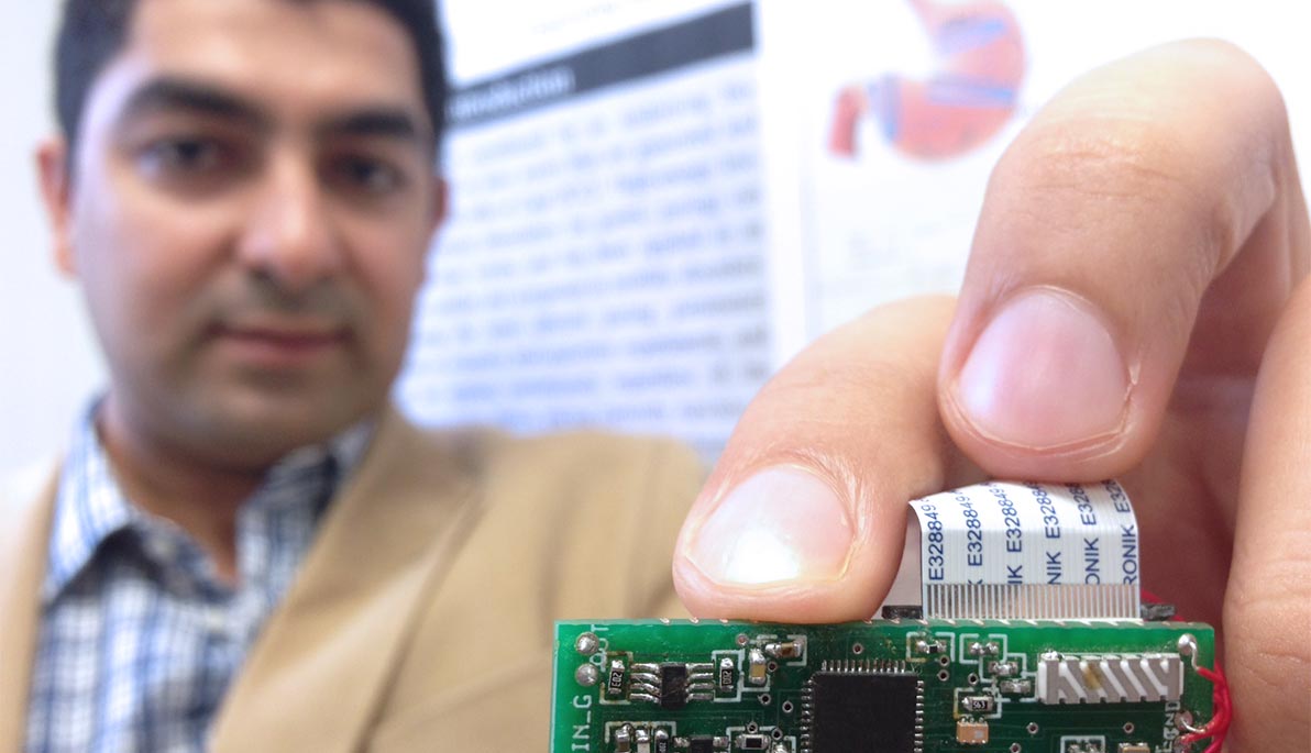 Professor Aydin holding a circuit chip