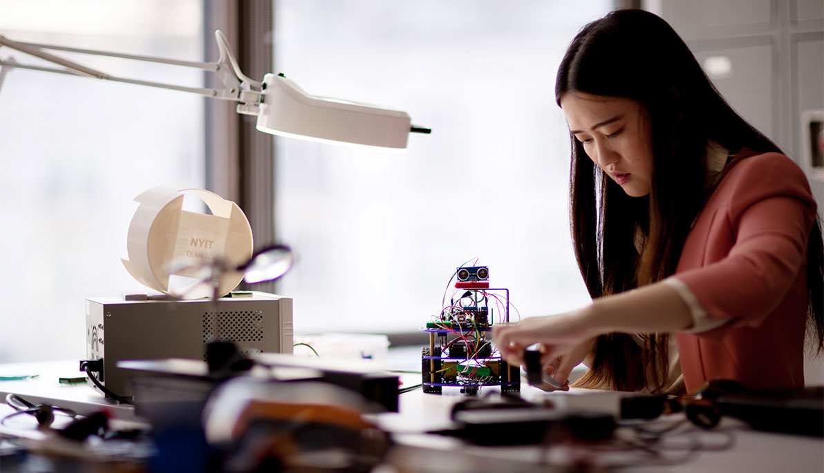 NYIT student working on a robot.