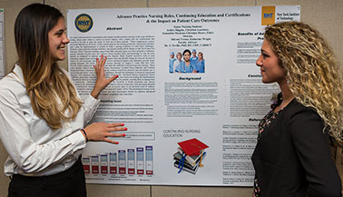 Two female NYIT students looking at a poster presentation