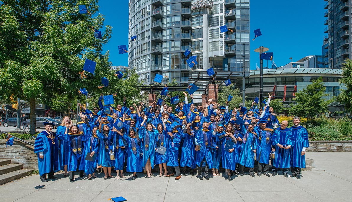 NYIT students tossing their caps in the air.
