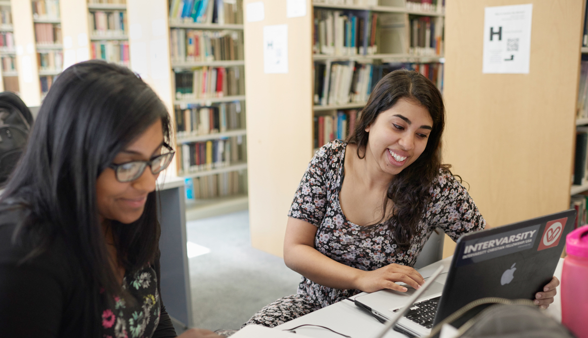 Two NYIT students on their laptops in Wisser Library.