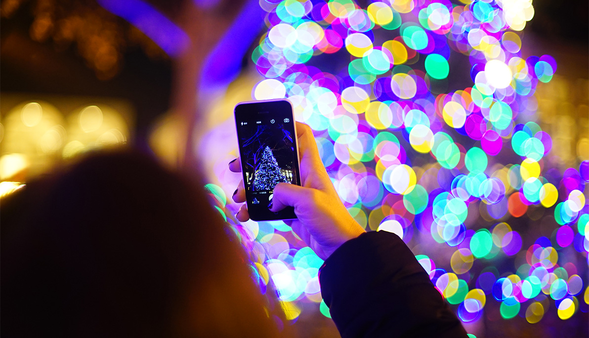 Someone taking a photo of a Christmas tree with their phone