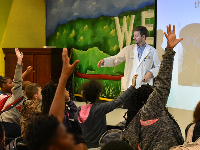 Daniel Parrinello, a second-year medical student at NYITCOM-Arkansas, leads elementary school students through an exercise at a National Outreach for Diversity event