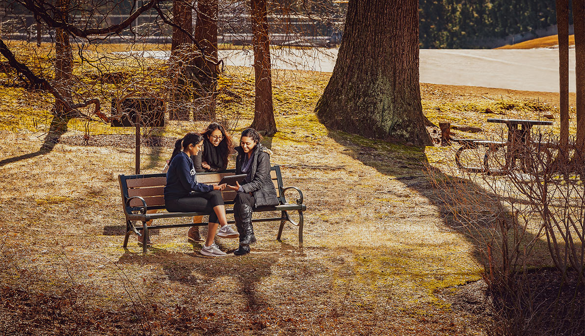 Students sit on a bench along the Healing Path on the Long Island campus.