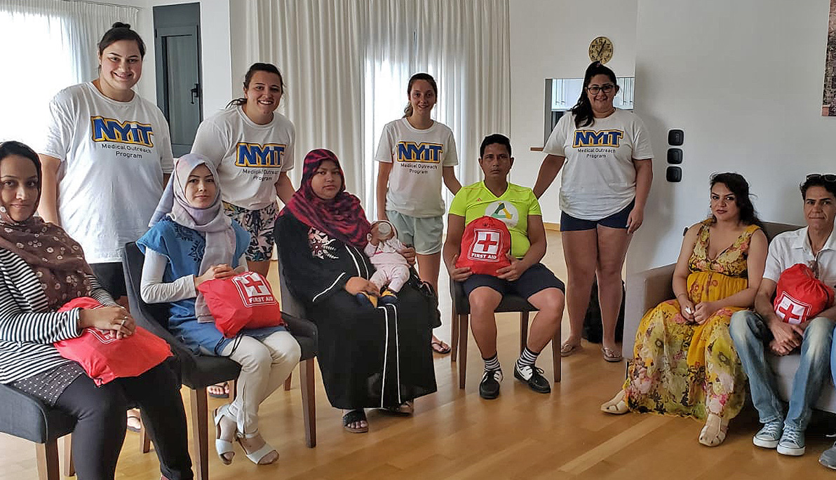 NYIT School of Health Professions students pose with refugees.
