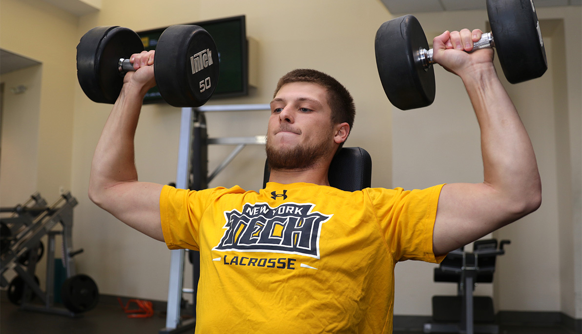 New York Tech men’s lacrosse player lifting weights.