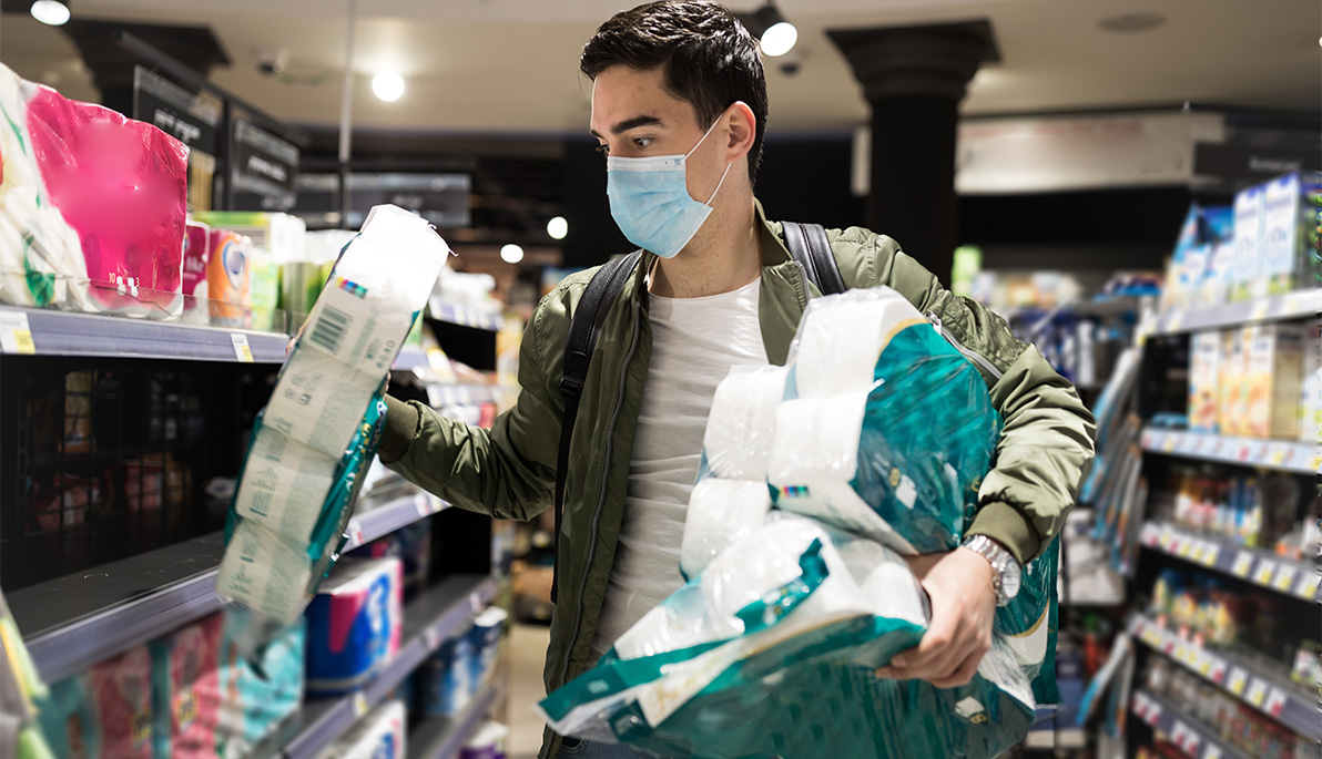 Man in supermarket buying toilet paper