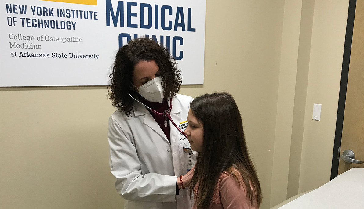 Assistant Professor Christine Hartford examining a young patient.