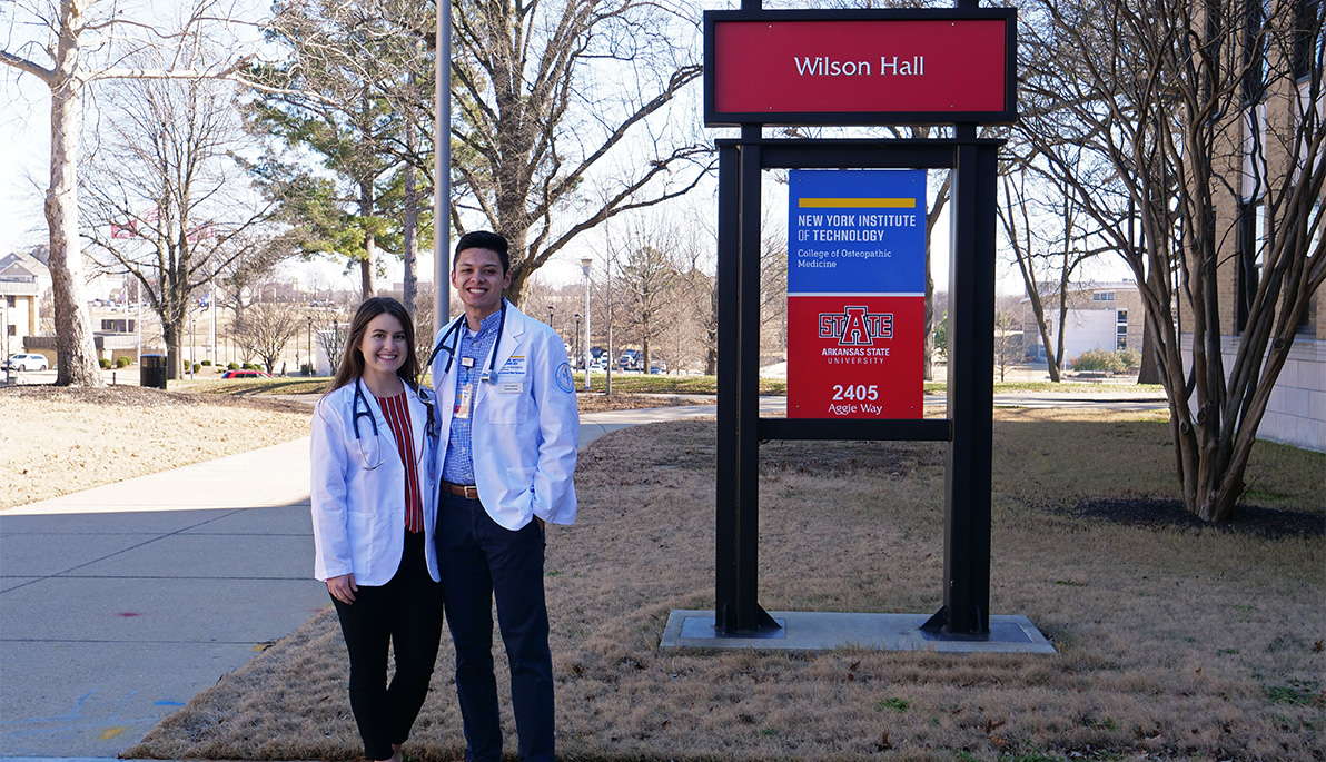 NYITCOM students Tyler and Shana Childress in front of sign on Jonesboro campus