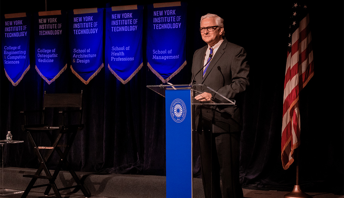 New York Tech President Hank Foley at a podium