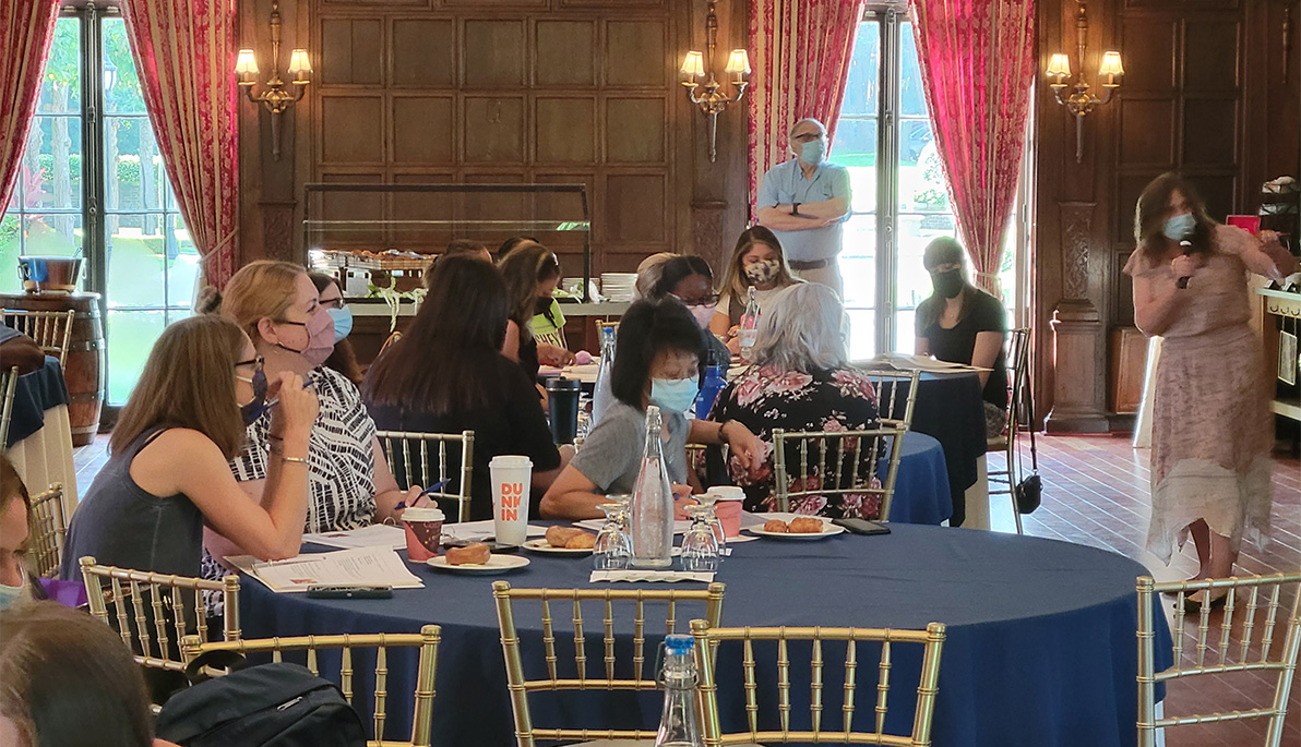 Educators sitting at tables at NYIT de Seversky Mansion