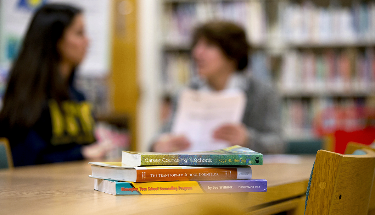 Books in front of people in a blurred background
