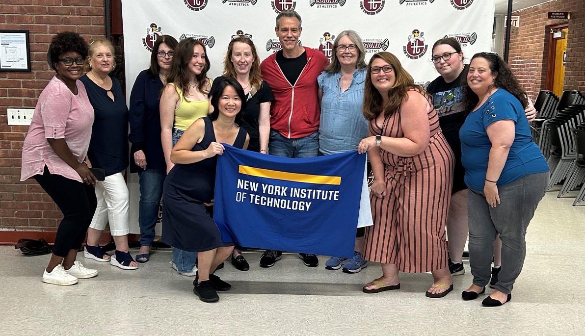 Adam Pascal with members of the New York Tech community holding a New York Institute of Technology banner