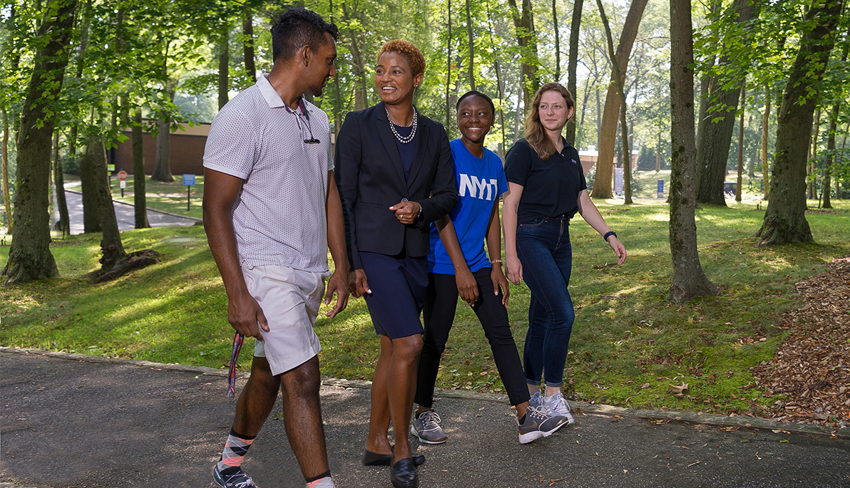 Tiffani Blake walking with students on the Long Island campus.