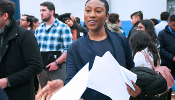 Student at career fair holding papers