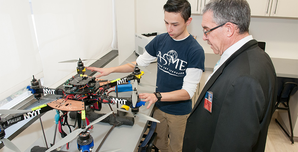 Student shows professor a multi-propeller NYIT drone