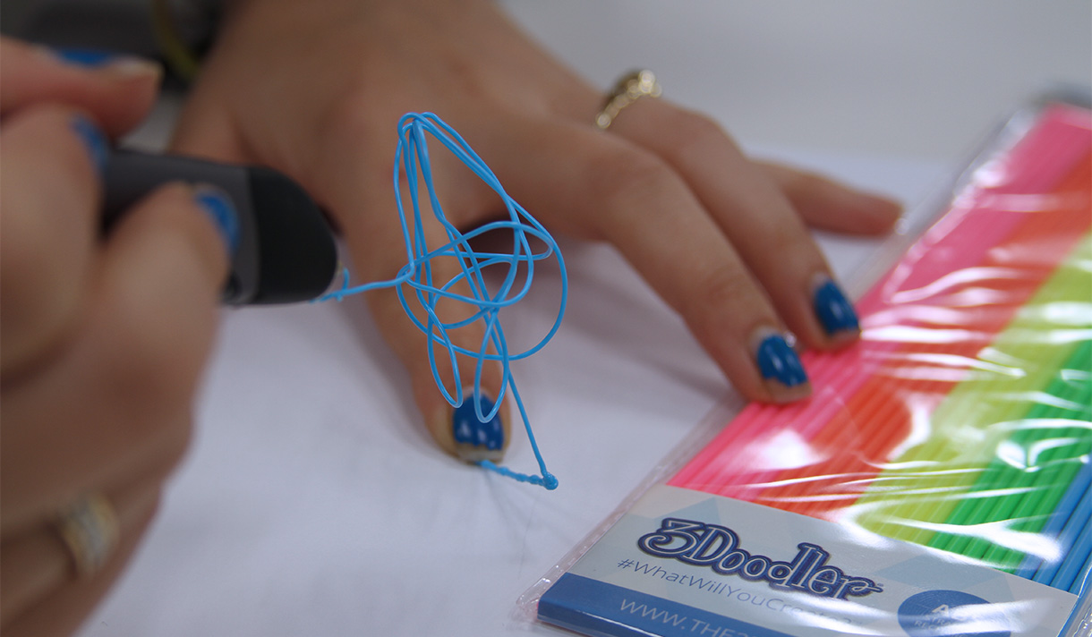 Closeup of hand using a pen that produces 3D plastic