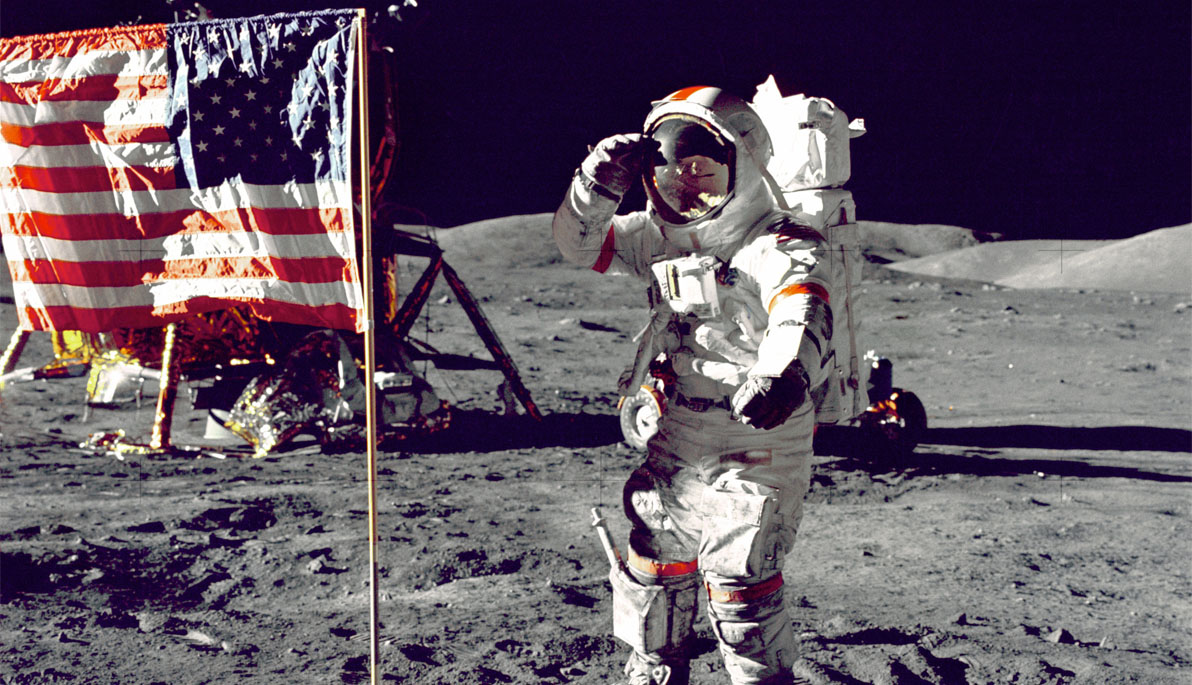 Astronaut saluting next to American flag