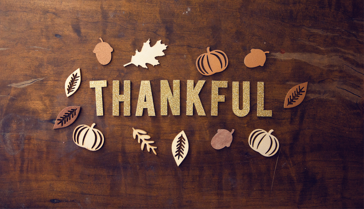 Art of leaves and pumpkins around the word "Thankful"