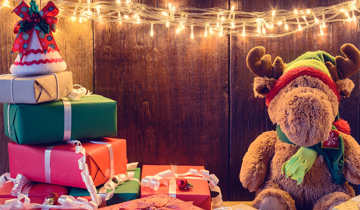 A moose stuffed animal with Christmas presents