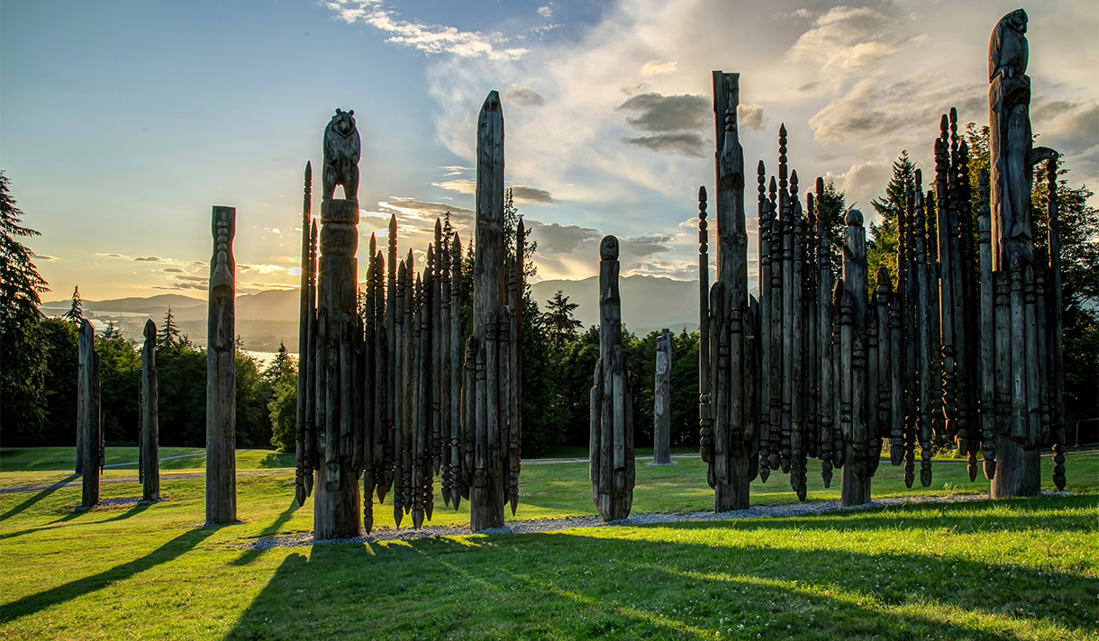 Long Wooden Pole Sculptures on Grass