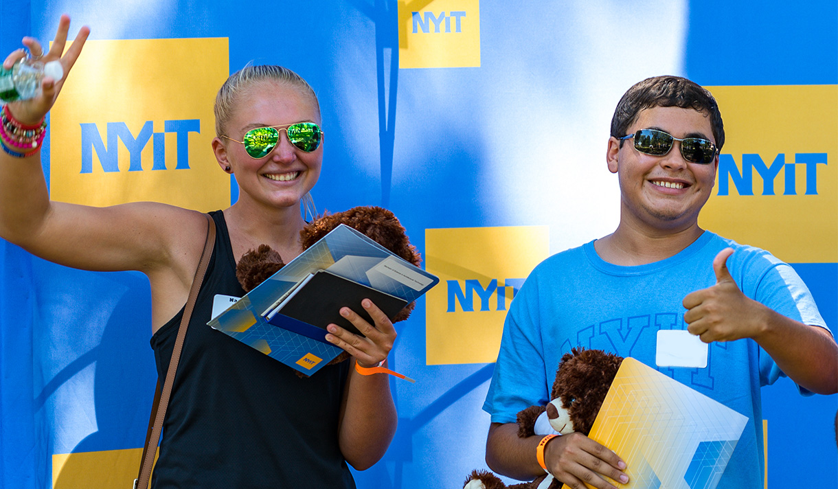 NYIT students posing against NYIT backdrop