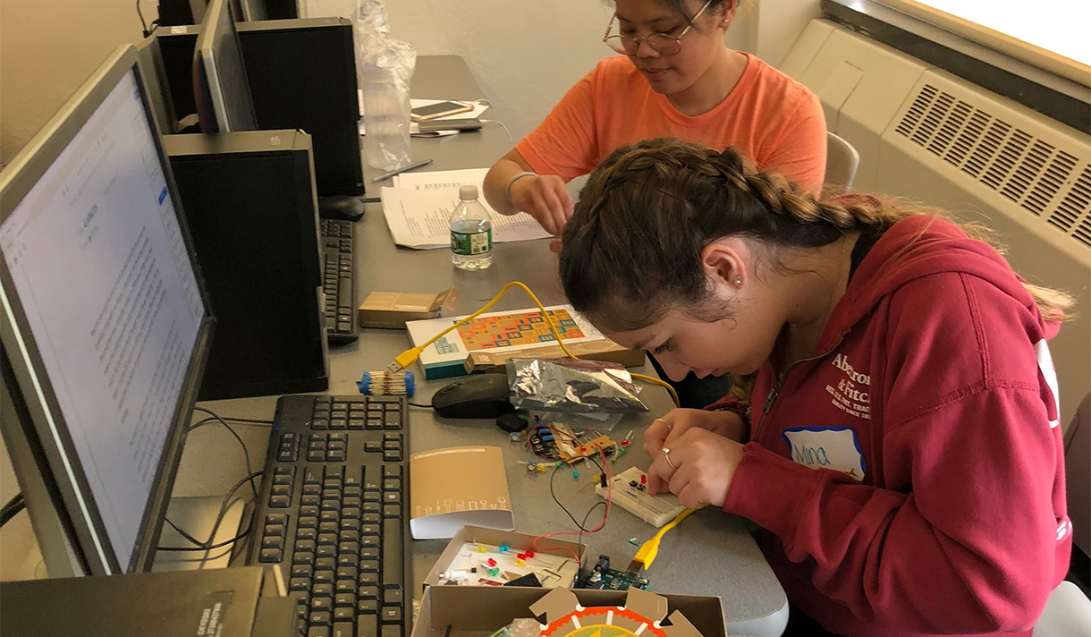 two women engineering students at their computer workbench 