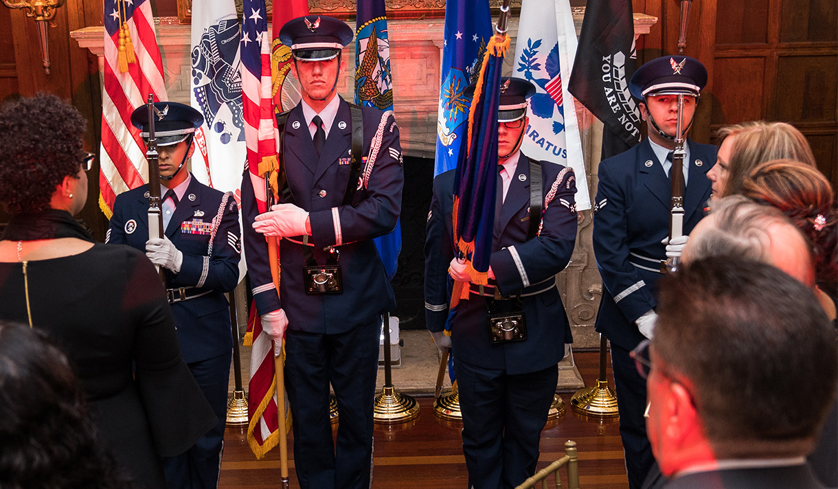 Military color guard holding flags at veterans event