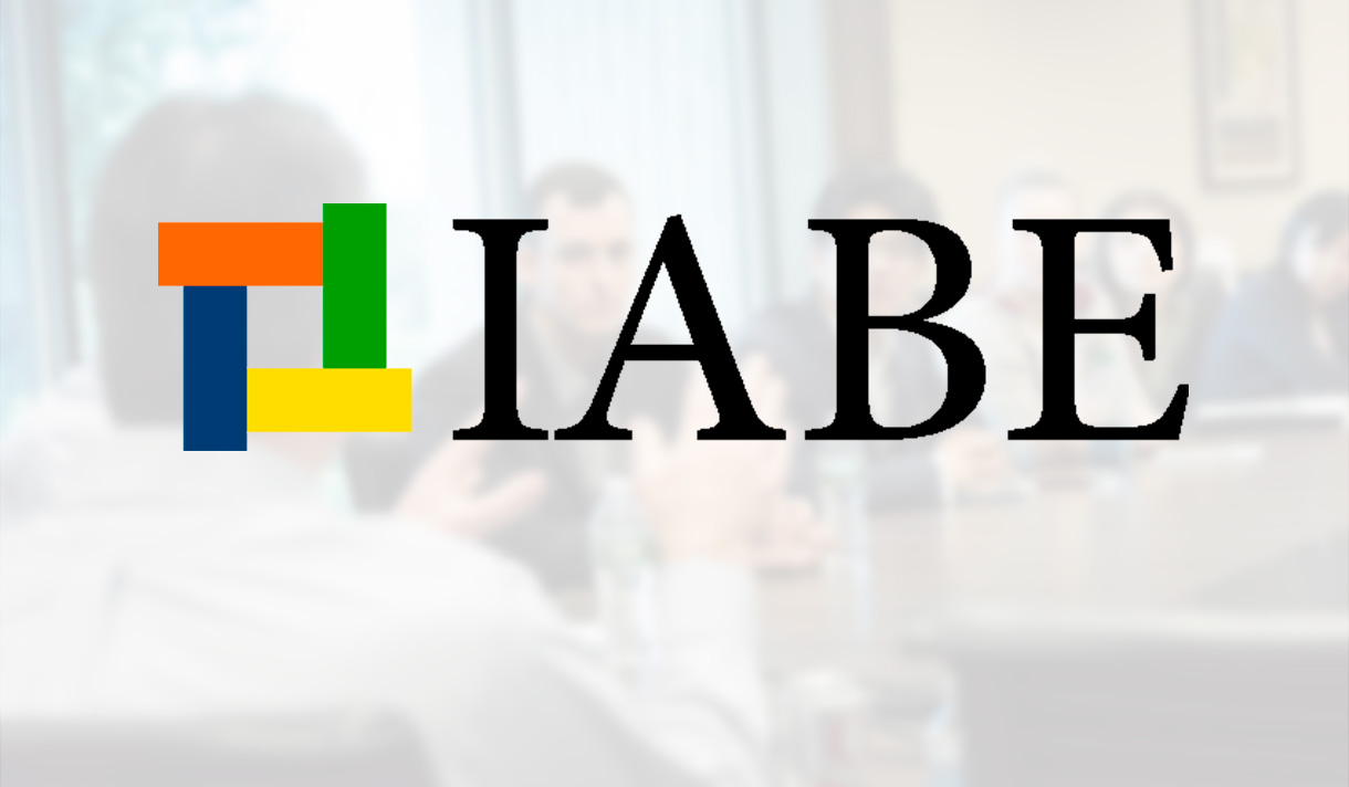 IABE logo over a business meeting image