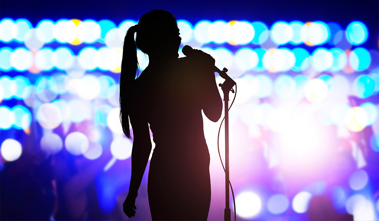 Silhouette of a singer at a mic.