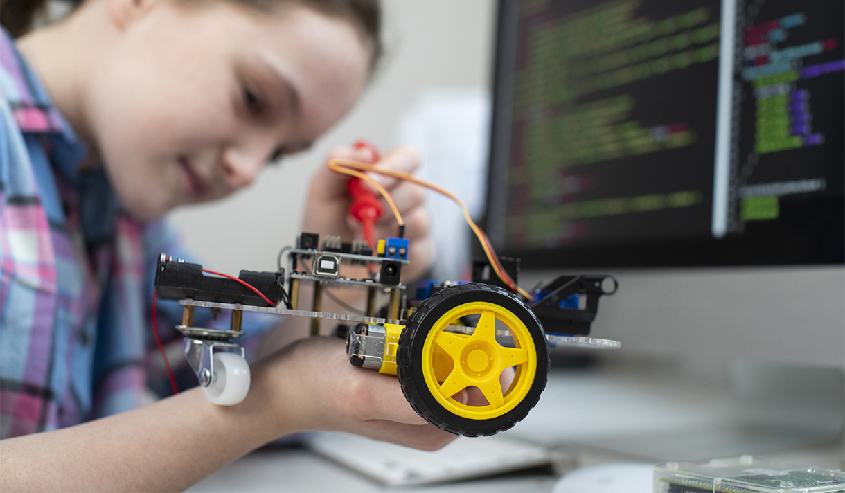 Young female student working on a robot