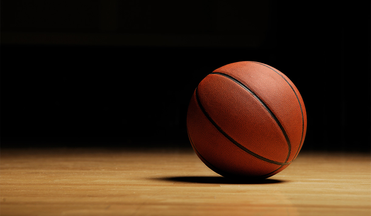 A basketball in front of a dark backdrop in an ominous silhouette 