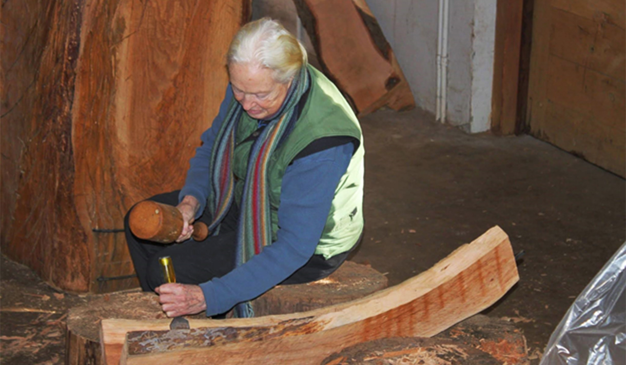 Artist Emilie Brzezinski working on a wood sculpture.