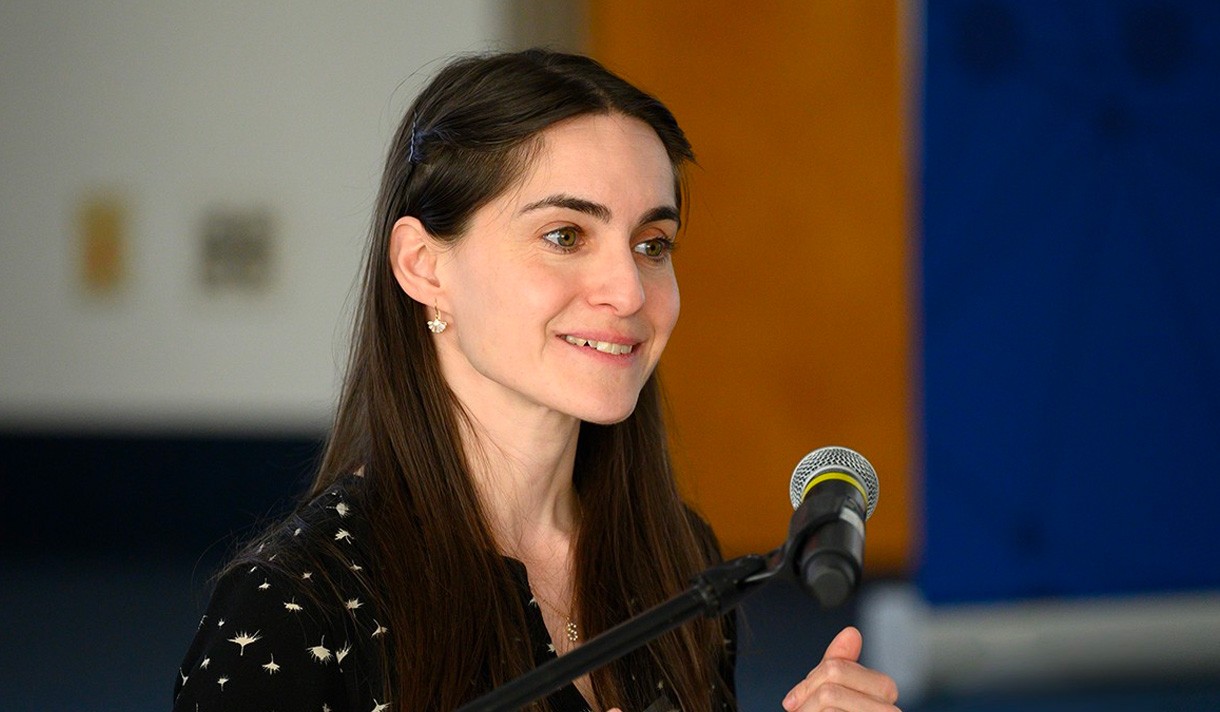 ; Sophia Domokos, Ph.D speaking into a a microphone