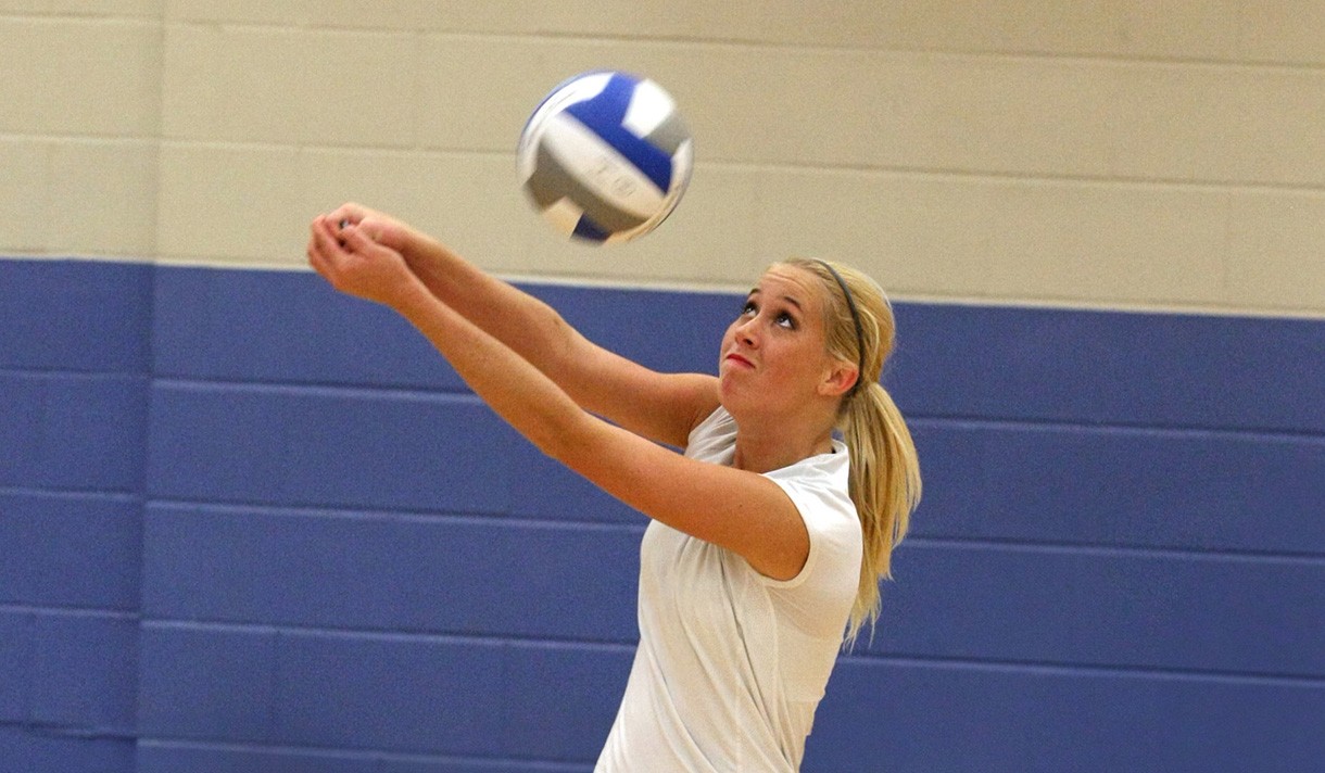 A woman playing volleyball in a gym