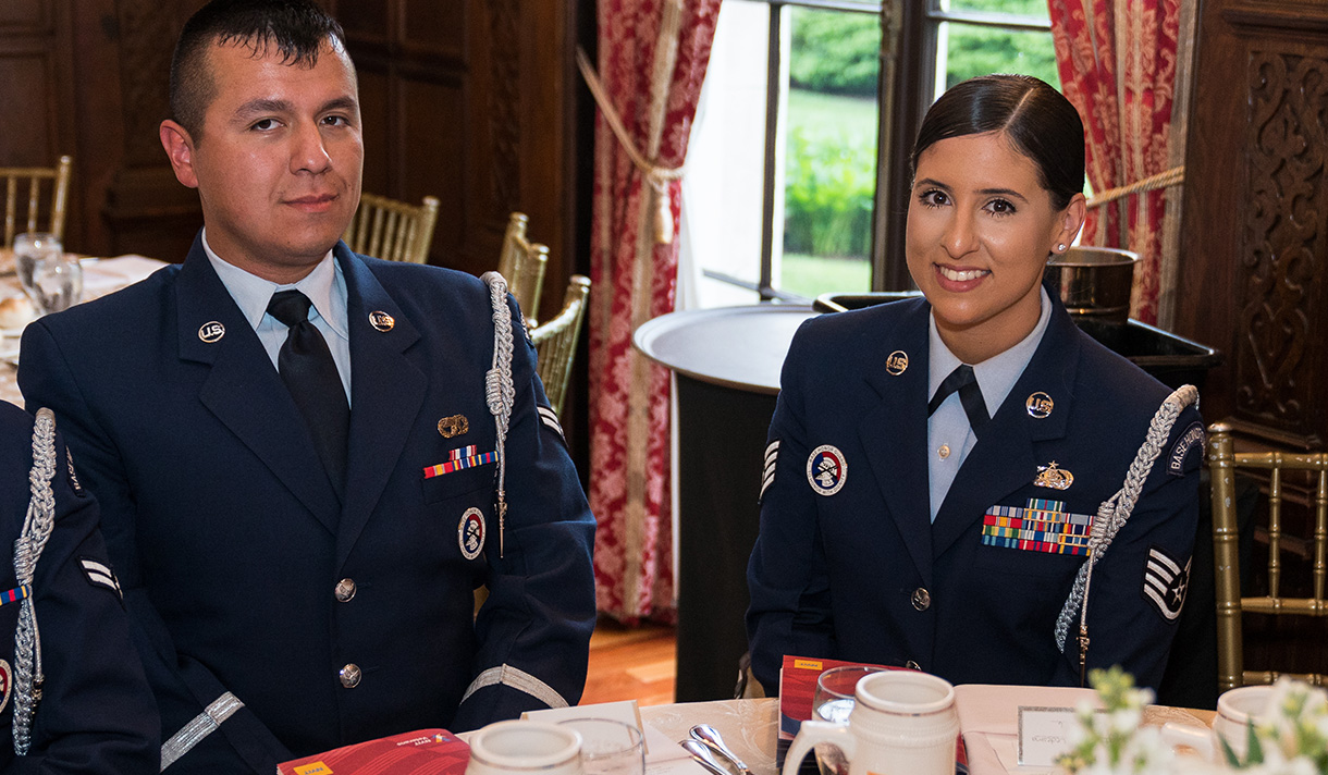 Two student veterans in uniform at a luncheon table