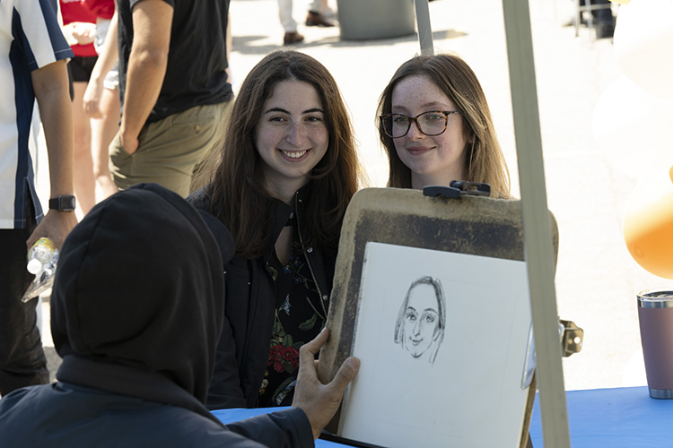 Sitting for a portrait with a caricaturist. (Long Island)