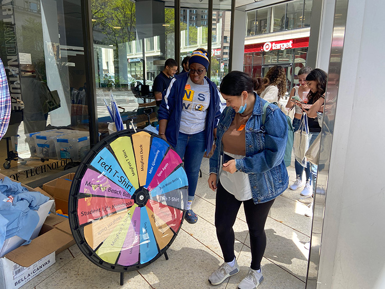 Students spin a wheel to win a variety of New York Tech- and MayFest-themed prizes. (New York City)