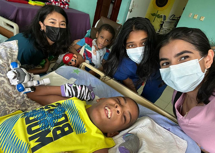 Medical students (in masks) visit with children at the Casa de Luz orphanage.